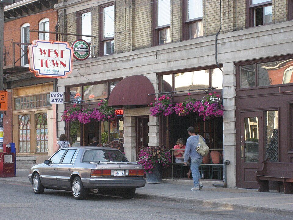 Shops and a flower-decked pub patio on Locke Street South, Hamilton
